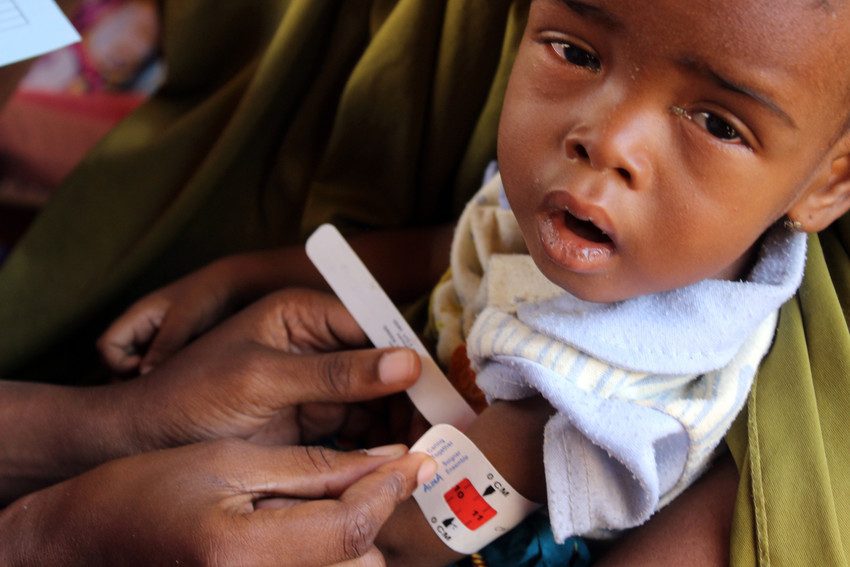 Halima has her arm measurement taken at a health facility supported by Plan International in Maidiguri.