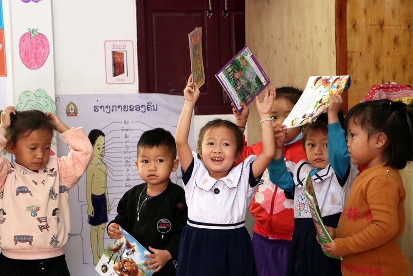 Children enjoying books at a preschool in Laos. Early childhood education is essential for development. 